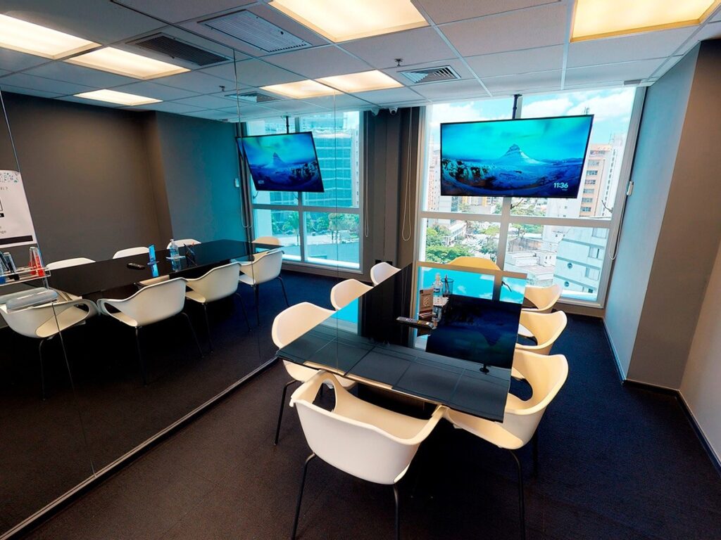Sala de reunião do BClub Coworking com televisor e vista para a cidade
